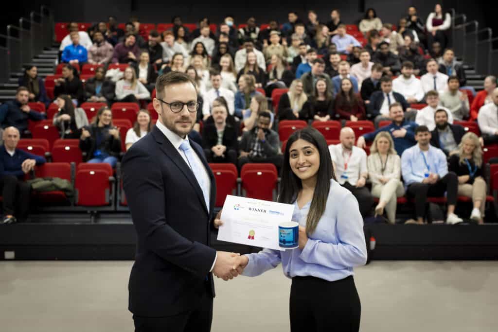 BSc Sports and Exercise Therapy Course Director presenting the winner of the award with a certificate and prize